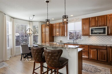 A bright, inviting kitchen with warm wood cabinetry, granite counters, and a spacious breakfast nook perfect for casual entertaining.
