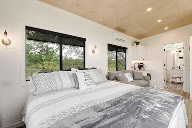 Bedroom with wood finished floors, a wall unit AC