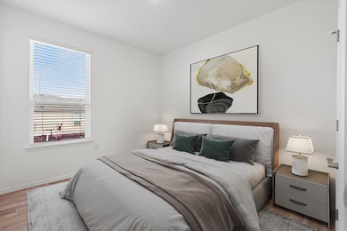 Bedroom featuring wood finished floors and basebo