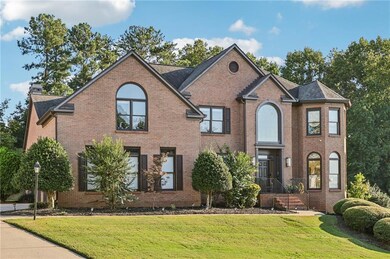 Traditional-style home with a front lawn, brick siding, and a chimney
