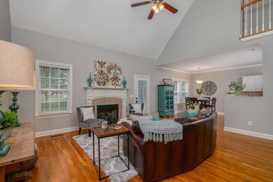 LIVING ROOM HAS SOARING CEILINGS AND A COZY FIREPLACE. REAL HARDWOOD FLOORS IN ALL OF THE MAIN LIVING AREAS DOWNSTAIRS.