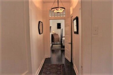 Hallway with Pretty Chandelier, the Bathroom is th