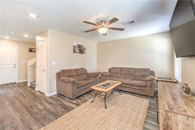 Living room featuring ceiling fan, wood finished f