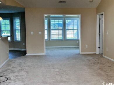 Carpeted empty room with baseboards and vaulted ceiling