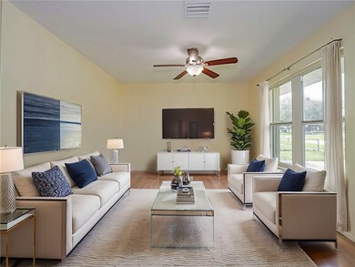 Living room with wood finished floors and ceiling fan - Virtually staged