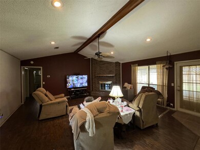 Living room with vaulted ceiling with beams, wood-
