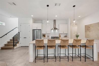 Kitchen featuring wall chimney range hood, tastef