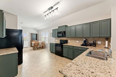 Kitchen featuring black appliances, a sink, green