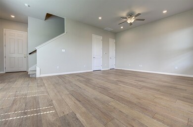 Empty room featuring ceiling fan, stairway, wood 
