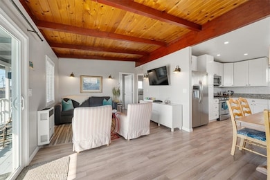 Upstairs features an open floor plan with beautiful open-beam wood ceilings creating a warm cabin-style ambiance