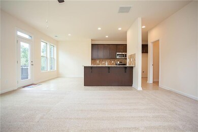 Kitchen featuring backsplash, open floor plan, dark brown cabinets, a breakfast bar, and recessed lighting