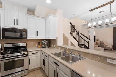Kitchen with black microwave, gas range, a sink, 