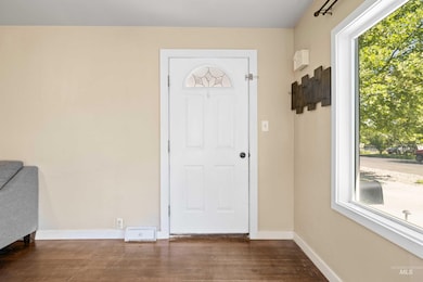 Entryway featuring dark wood-style floors and baseboards