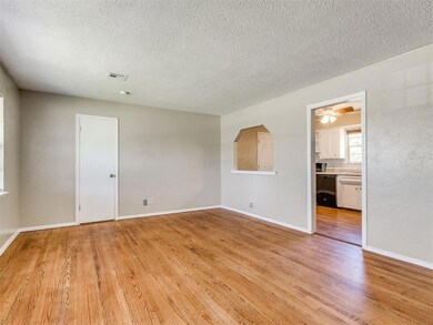 Empty room with light wood finished floors, a textured ceiling, and ceiling fan