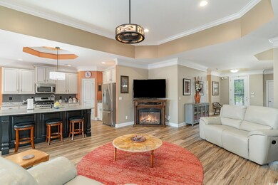Living room with a tray ceiling, crown molding, an