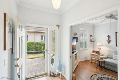 Foyer with ceiling fan, ornamental molding, wood f