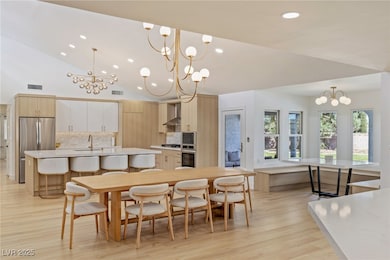 Kitchen with wall chimney range hood, a chandelier