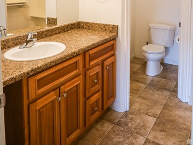 Bathroom featuring dark tile patterned floors and vanity