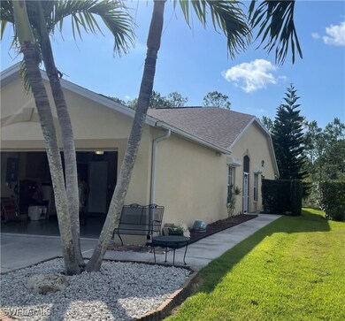 View of side of home with stucco siding, a lawn, a