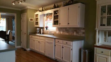 The Kitchen Features Open Cabinetry & Tiled Backsplash!