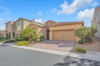 Mediterranean / spanish house featuring stucco siding, decorative driveway, a tile roof, a garage, and stone siding