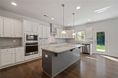 Kitchen with white cabinets, wall chimney exhaust 