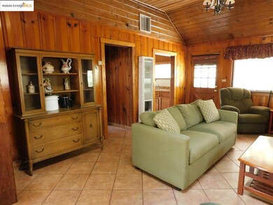Living room with light tile patterned floors, wood ceiling, wood walls, and vaulted ceiling