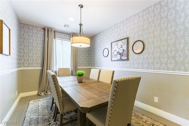 Dining space with wallpapered walls and wood finished floors