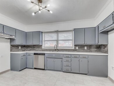 Kitchen with gray cabinets, ornamental molding, si
