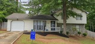 Tri-level home featuring an attached garage and concrete driveway