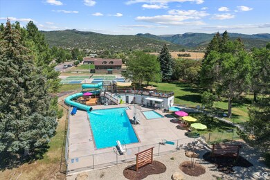 Community pool with a patio, a water slide, and a mountain view.