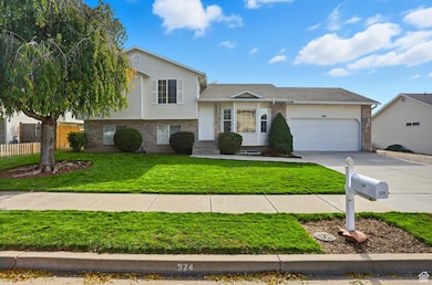 Tri-level home featuring brick siding, concrete driveway, and an attached garage