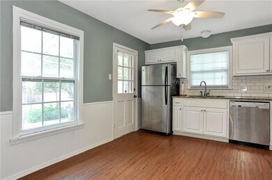Kitchen featuring ceiling fan, white cabinets, sink, tasteful backsplash, and stainless steel appliances