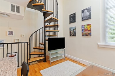 Staircase featuring wood finished floors, baseboar
