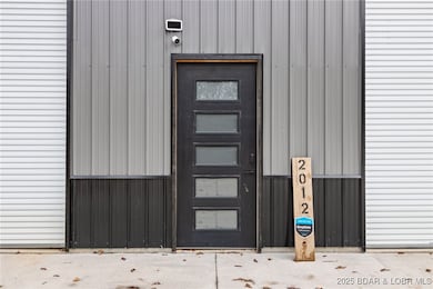 Shop entrance located between overhead doors.