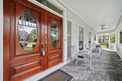 The front of the house welcomes you with a large wrap around patio complete with pavers, 2 ceiling fans and views of the neighborhood. Notice the freshly stained double doors.