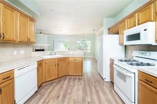 Kitchen with white appliances, a peninsula, a sin