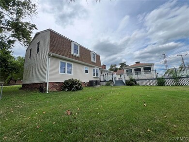 Rear view of house with a deck and a lawn