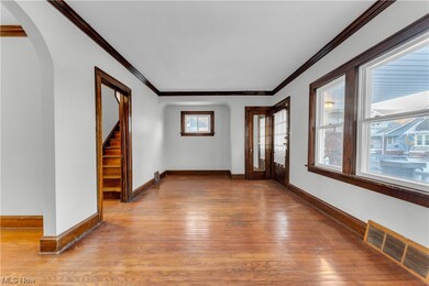 Spare room featuring crown molding and light hardwood / wood-style flooring