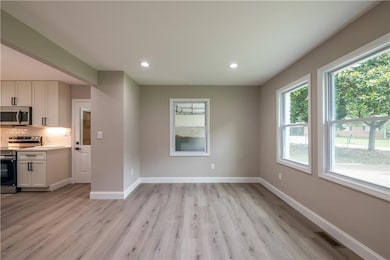 Kitchen with stainless steel appliances, healthy amount of natural light, white cabinetry, light wood-style floors, and recessed lighting