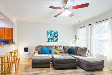 Living room with light wood finished floors and ceiling fan