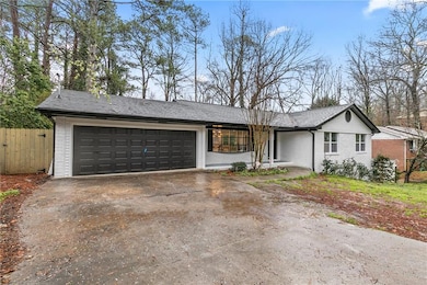 View of front of home featuring fence, roof with s