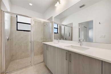Full bathroom with double vanity, a stall shower,
