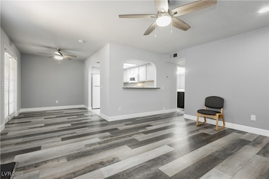 Living area with ceiling fan, wood finished floors