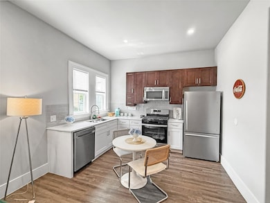 Kitchen featuring appliances with stainless steel finishes, decorative backsplash, light wood-type flooring, and recessed lighting