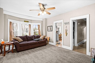 Carpeted living room with ceiling fan