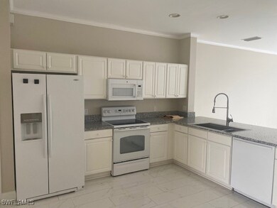 Kitchen with white cabinetry, white appliances, sink, and ornamental molding