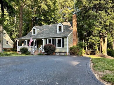 Cape cod home featuring covered porch and view of