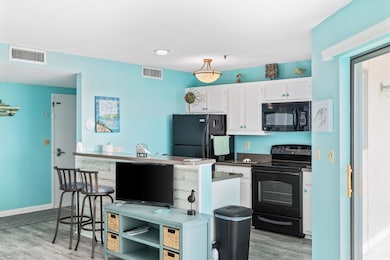 Kitchen with a kitchen island, white cabinetry, a 