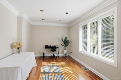 Office with wood finished floors, crown molding, and recessed lighting